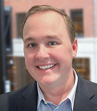 Man smiling in suit.